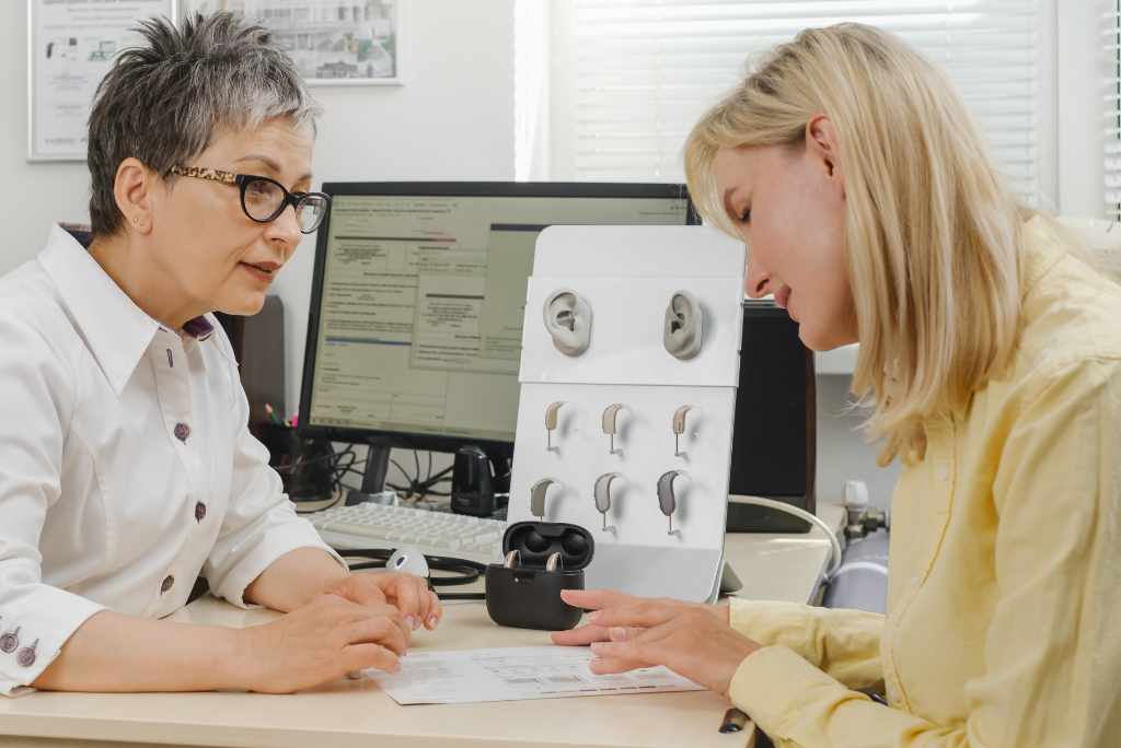 Woman discussing hearing aid features with a doctor