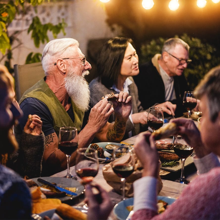Group of diners enjoying food and wine at outdoor restaurant table