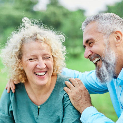 Couple smiling together while enjoying comfortable hearing aid use