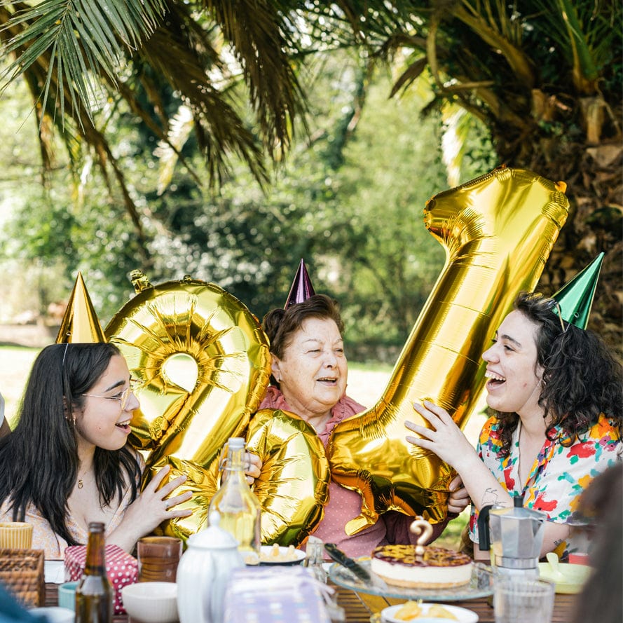 Family celebrating birthday together at outdoor gathering table