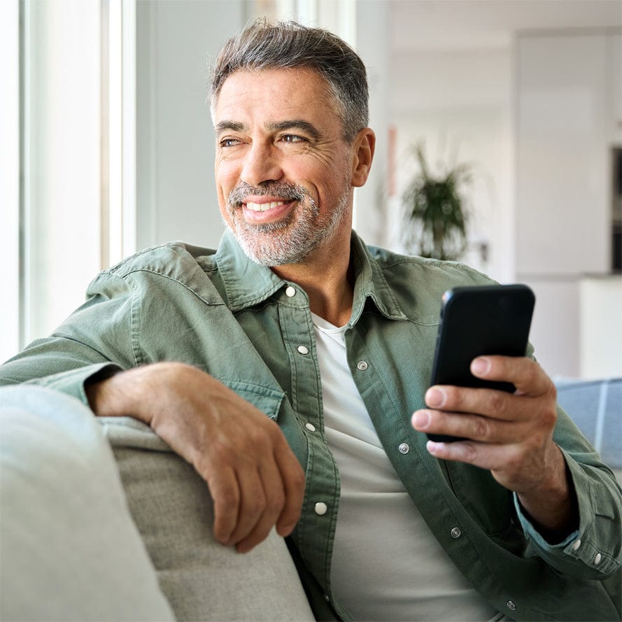 Man smiling while having clear conversation on smartphone at home